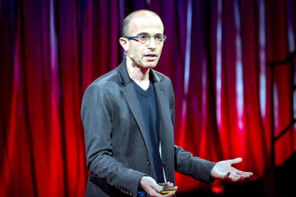 na pozornici drži predavanje